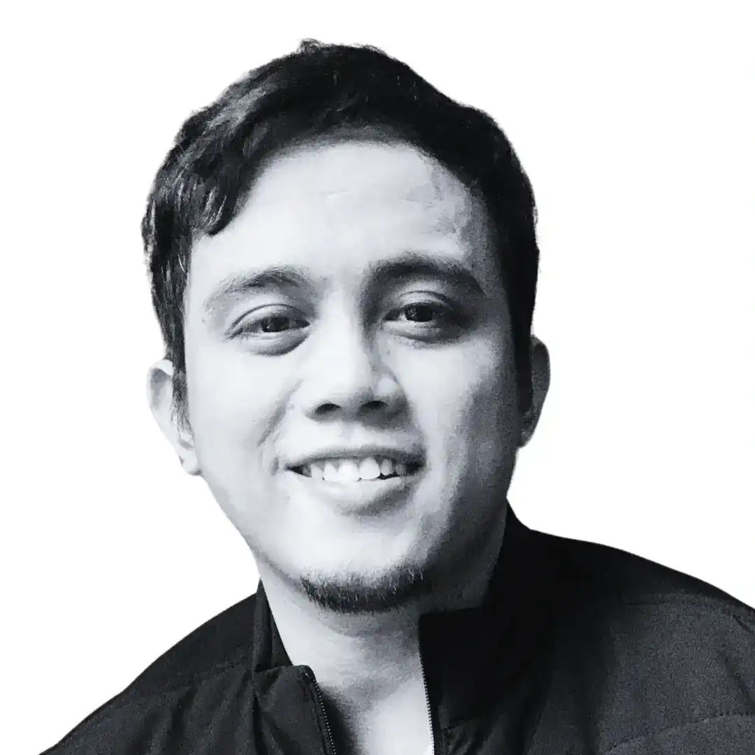 A black and white portrait of a smiling young man with short, dark hair and a bit of facial hair. He is wearing a jacket with the collar slightly raised, exuding a vibe as natural as organic. The background is plain white. Opdee Digital Marketing