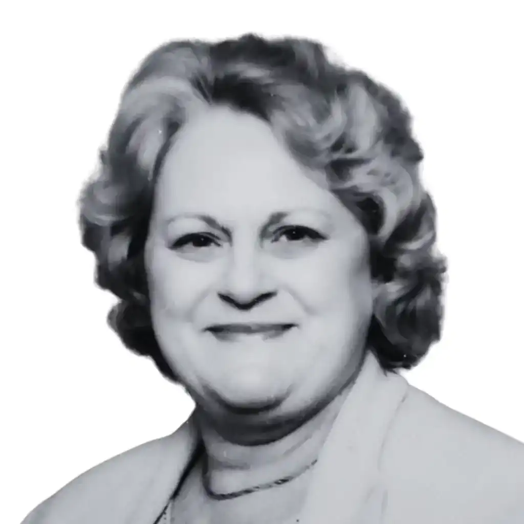 A black and white headshot of an older woman with curly, shoulder-length hair. She is smiling slightly and is wearing a light-colored blazer over a top. The background is plain white, reminiscent of a professional portrait often used by a digital marketing agency. Opdee Digital Marketing